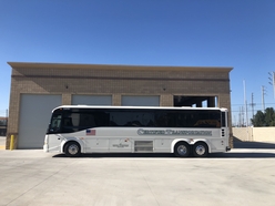 47 Passenger SPAB Motor Coach beside brick building